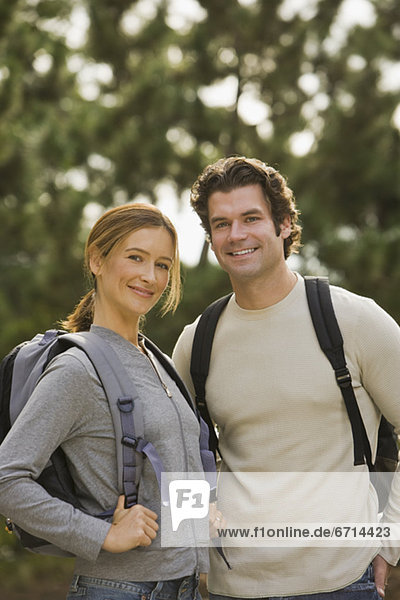 Couple wearing backpacks in woods