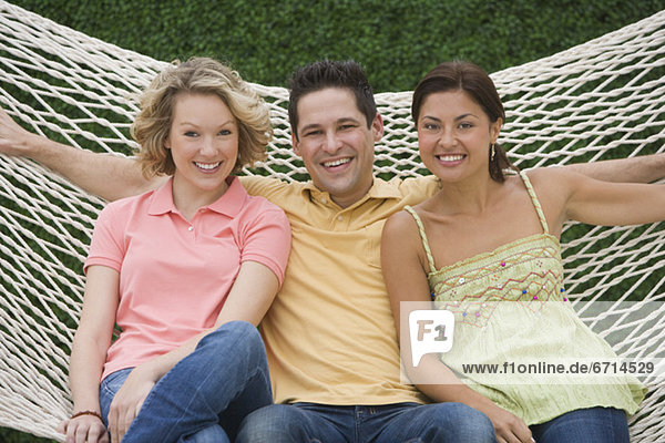 Multi-ethnic friends sitting on hammock