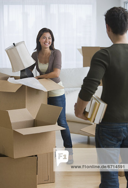 Multi-ethnic couple packing moving boxes