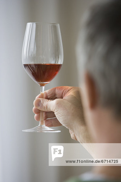 Man holding up glass of wine