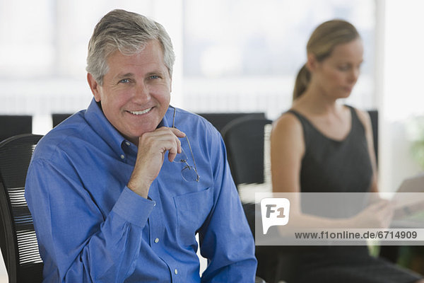 Businessman with businesswoman in background