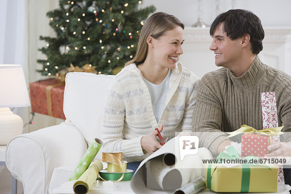 Couple wrapping Christmas gifts