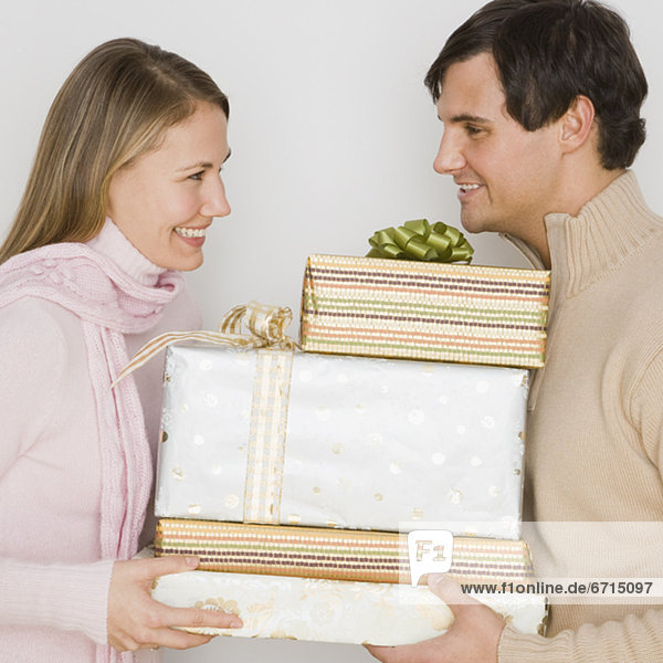 Couple holding pile of gifts