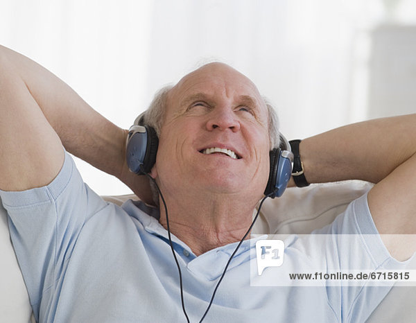 älterer Mann Kopfhörer anhören