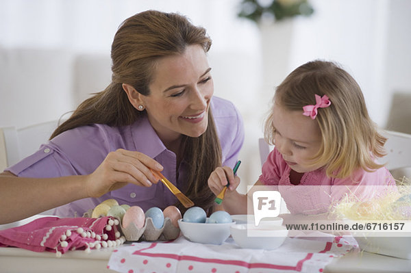 Mother and daughter decorating eggs