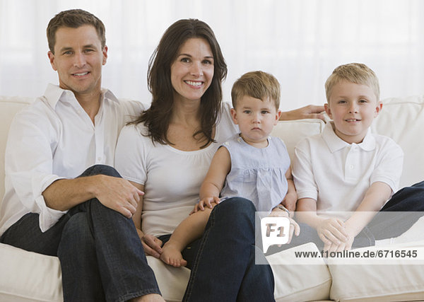 Family with two children sitting on sofa