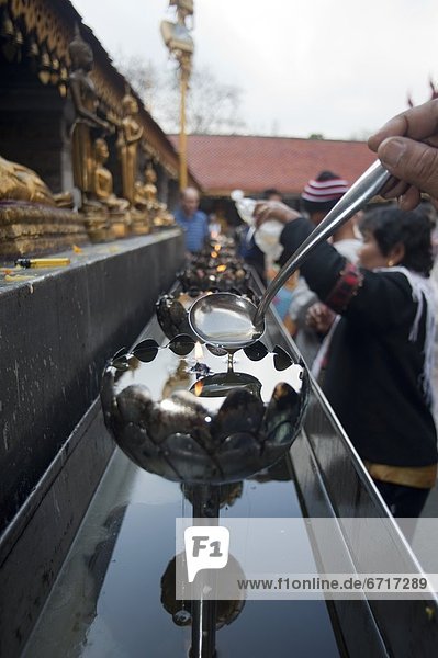 eingießen  einschenken  Kerze  fünfstöckig  Buddhismus  Chiang Mai  Öl  Thailand