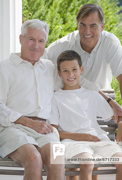 Three generations of men posing on porch