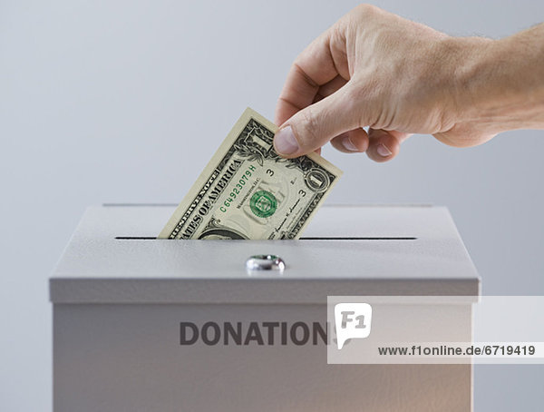 Man placing money in donation box