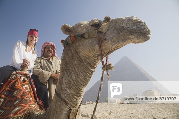 Young Female Tourist On A Camel With A Local Guide At The Pyramids Of Giza  Cairo  Egypt