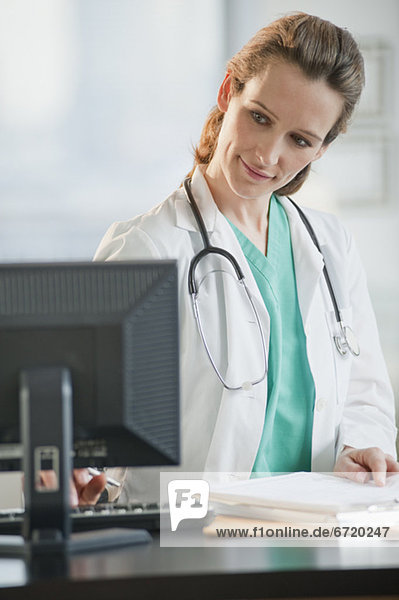 Female doctor looking at computer monitor