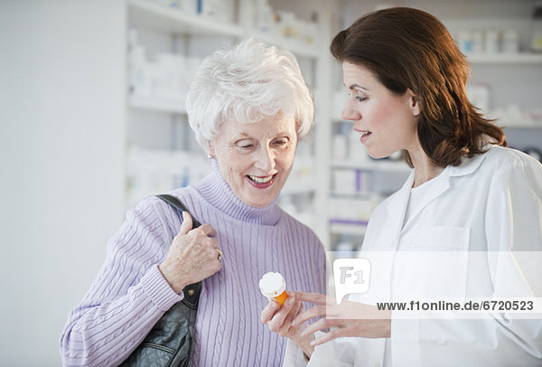 Pharmacist helping senior woman with prescription