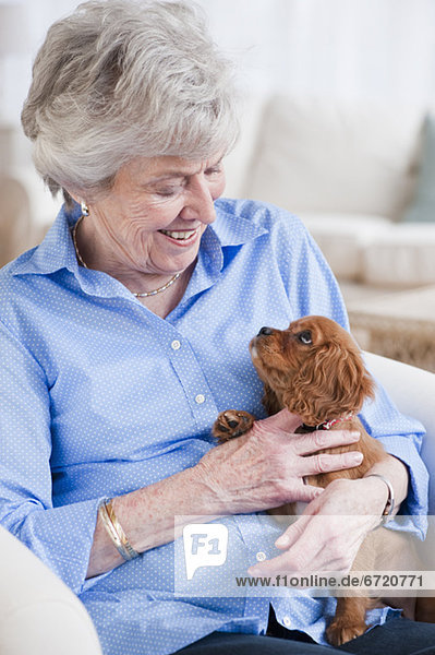 Senior woman hugging puppy