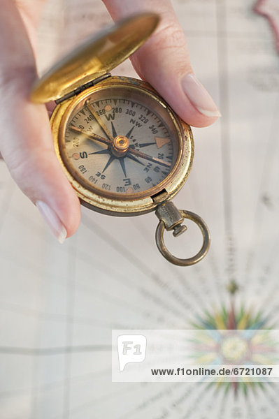Close-up of woman holding antique compass