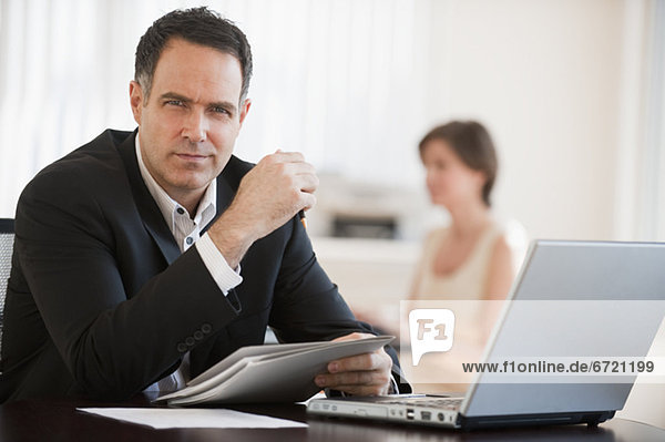 Portrait of successful mature businessman working in office