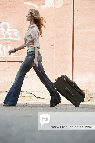 A woman walking with a suitcase