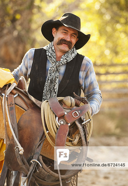 Cowboy holding saddle