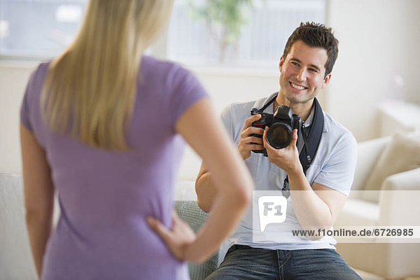 Man taking photograph of woman