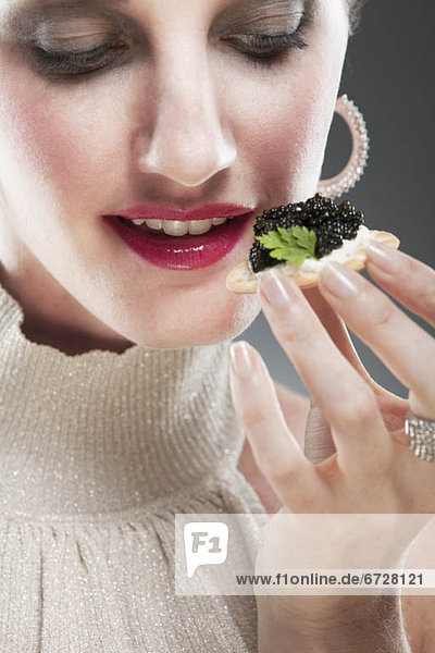 Frau  jung  essen  essend  isst  Kaviar  Biskuit