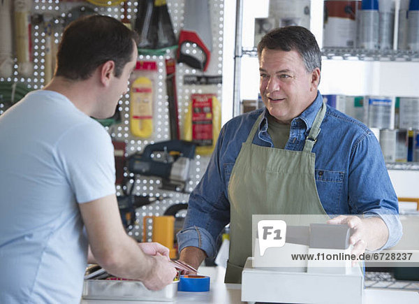 USA  New Jersey  Jersey City  Shop owner serving customer in hardware shop