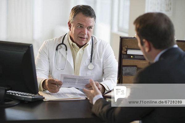 USA  New Jersey  Jersey City  Doctor discussing medical results with male patient in office