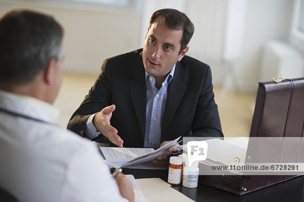 USA  New Jersey  Jersey City  Medical sales representative talking with doctor in office