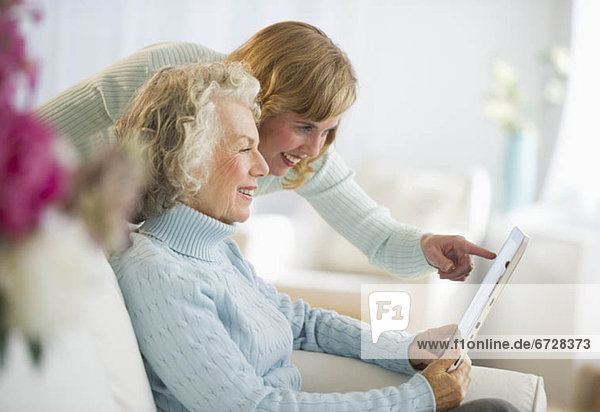Vereinigte Staaten von Amerika USA Senior Senioren benutzen Couch Tablet PC Tochter Mutter - Mensch