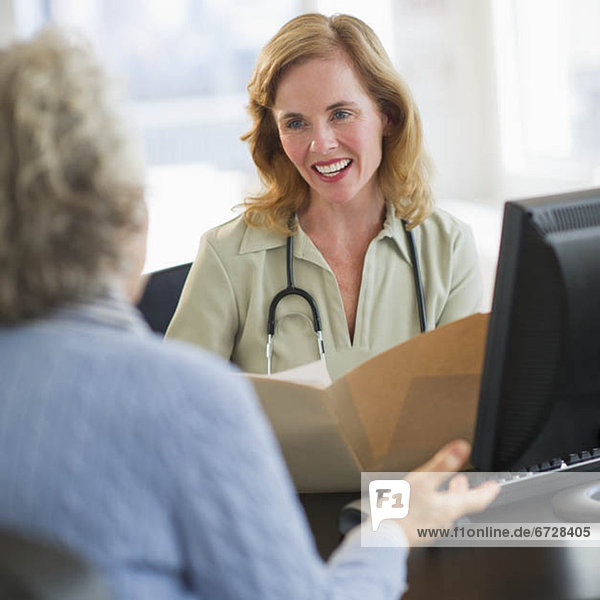 USA  New Jersey  Jersey City  Female doctor discussing medical record with patient in office