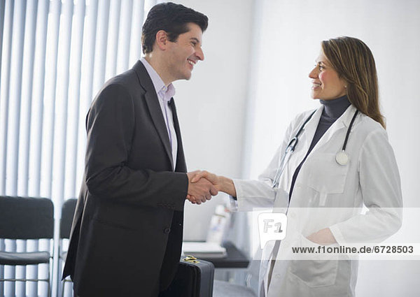 USA  New Jersey  Jersey City  Medical sales representative shaking hands with female doctor in office
