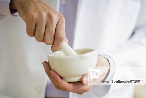 USA  New Jersey  Jersey City  Doctor preparing medicine using mortar and pestle