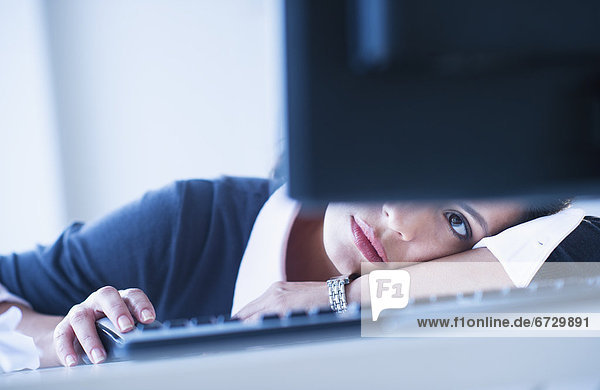 Businesswoman looking tired in front of computer