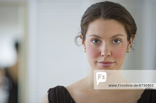 Junge Frau stützt Kopf auf Hand  Porträt vor weißem Hintergrund