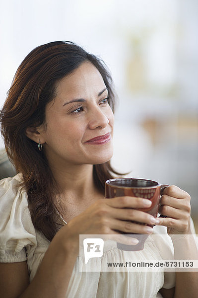 USA  New Jersey  Jersey City  portrait of smiling woman drinking tea