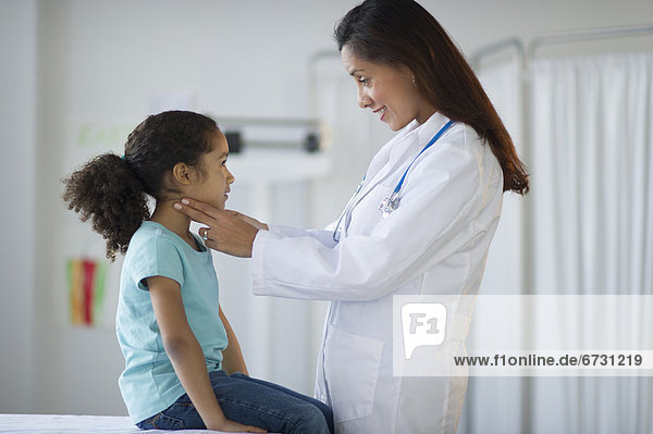 USA  New Jersey  Jersey City  female pediatrician examining girl (6-7) in doctor's office