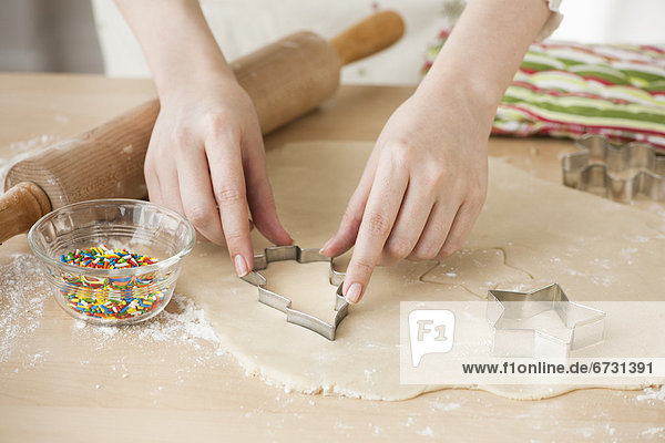 Woman preparing biscuits with pastry cutter