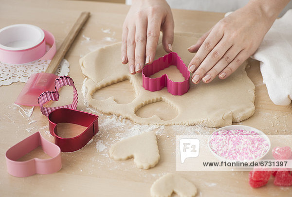 Woman preparing biscuits with pastry cutter