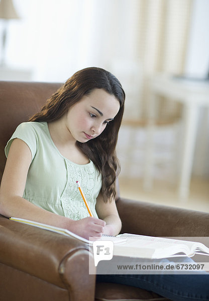 Portrait of teenage girl (14-15) doing homework