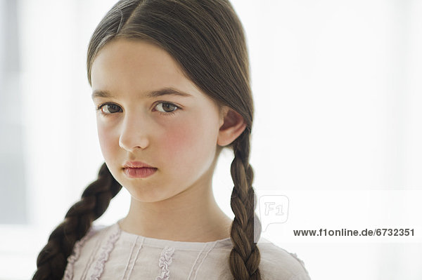 Portrait of sad girl (8-9) with braids
