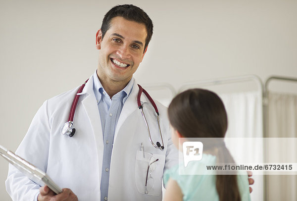 Portrait of doctor talking to girl (8-9)