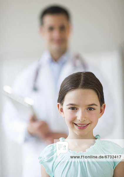 Portrait of girl (8-9)  with doctor behind