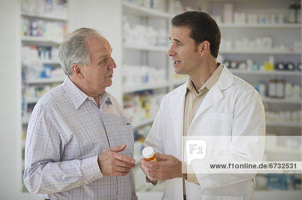 Pharmacist explaining use of medicine to patient