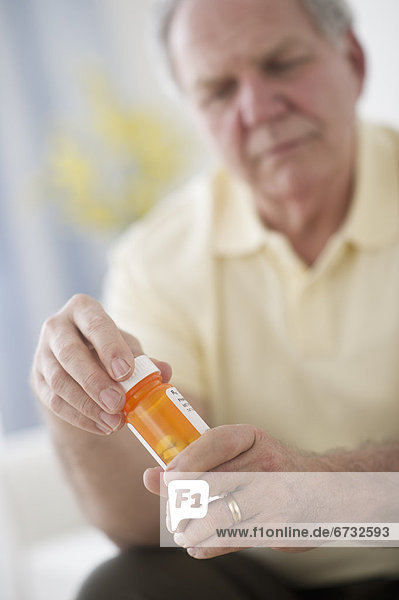 Portrait of senior man taking pills