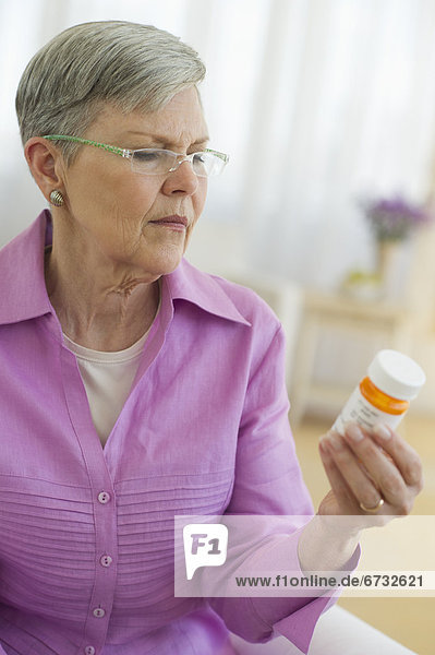 Senior woman looking at pill bottle