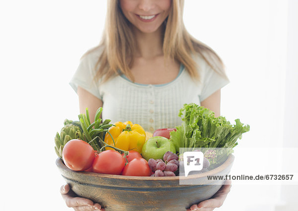 Woman holding bowl of organic fruit and vegetables