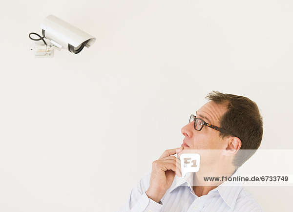Businessman under surveillance of security camera