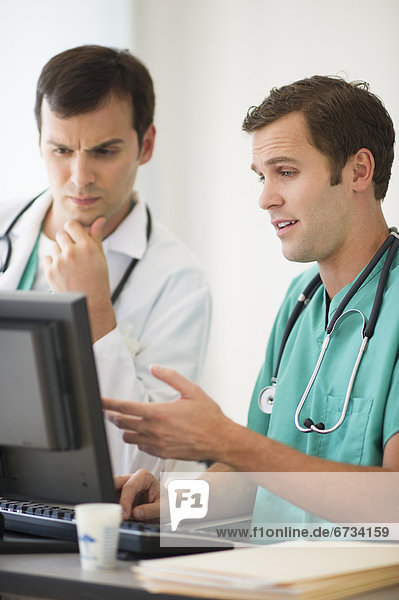 Doctors looking at computer