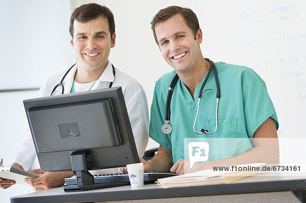 Portrait of two doctors using computer