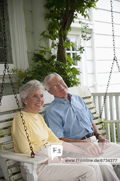 sitzend Senior Senioren schaukeln schaukelnd schaukelt schwingen schwingt schwingend Vordach Schaukel