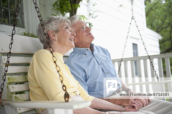 sitzend Senior Senioren schaukeln schaukelnd schaukelt schwingen schwingt schwingend Vordach Schaukel