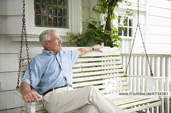 sitzend Senior Senioren schaukeln schaukelnd schaukelt schwingen schwingt schwingend Mann Vordach Schaukel